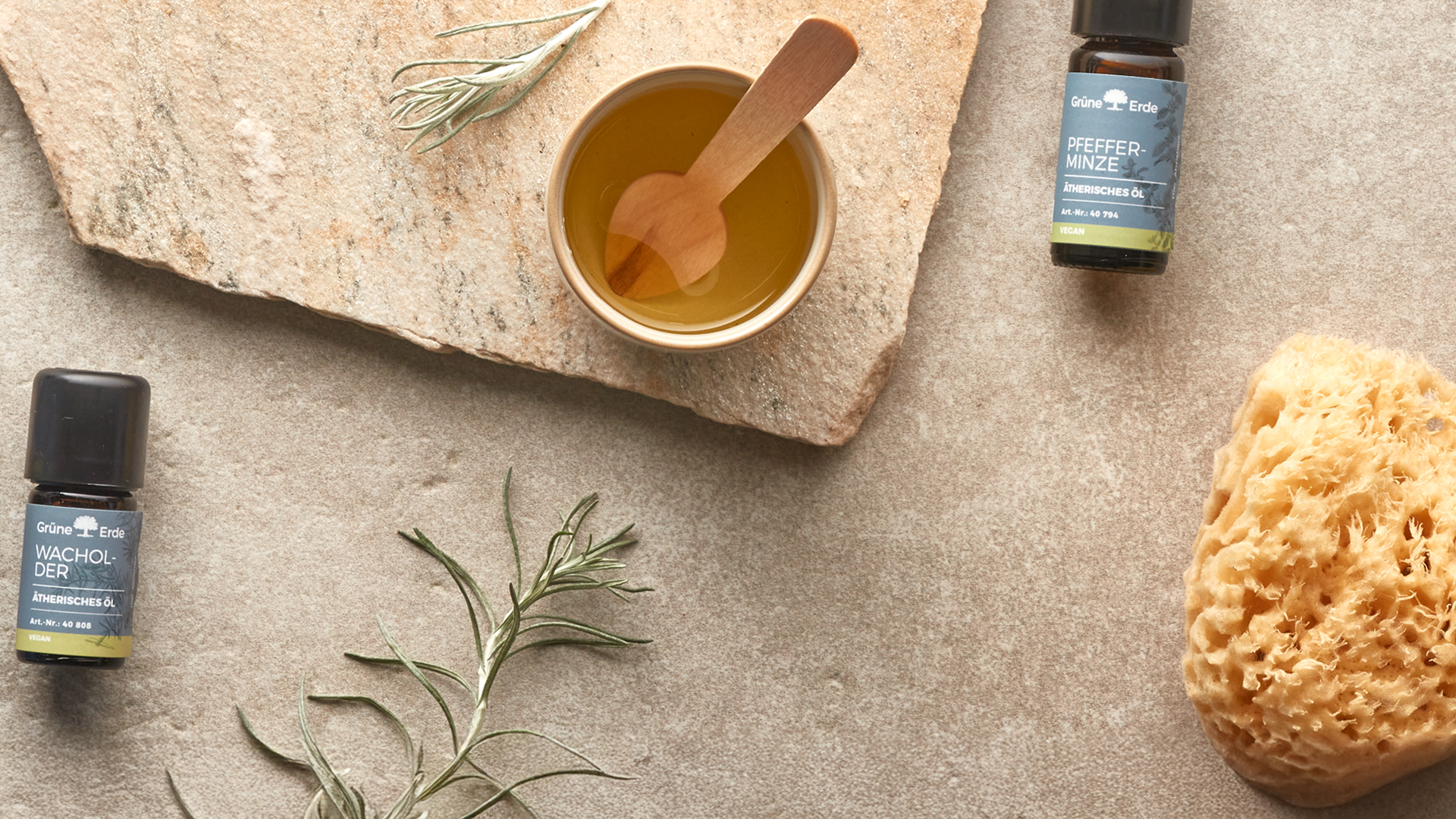 Schale mit Öl und Kräutern neben ätherischen Ölen natürlich arrangiert