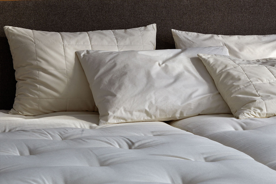 Vier unterschiedliche Kopfkissen auf einer hochwertigen Naturmatratze