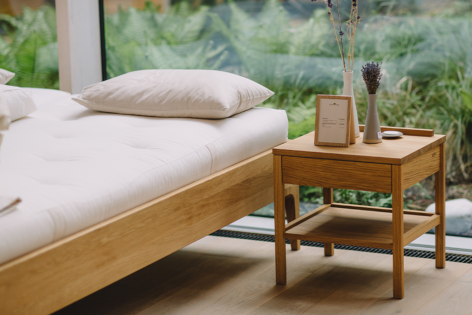 Ruhiges Schlafzimmer mit Holzbett und Blick ins Grüne