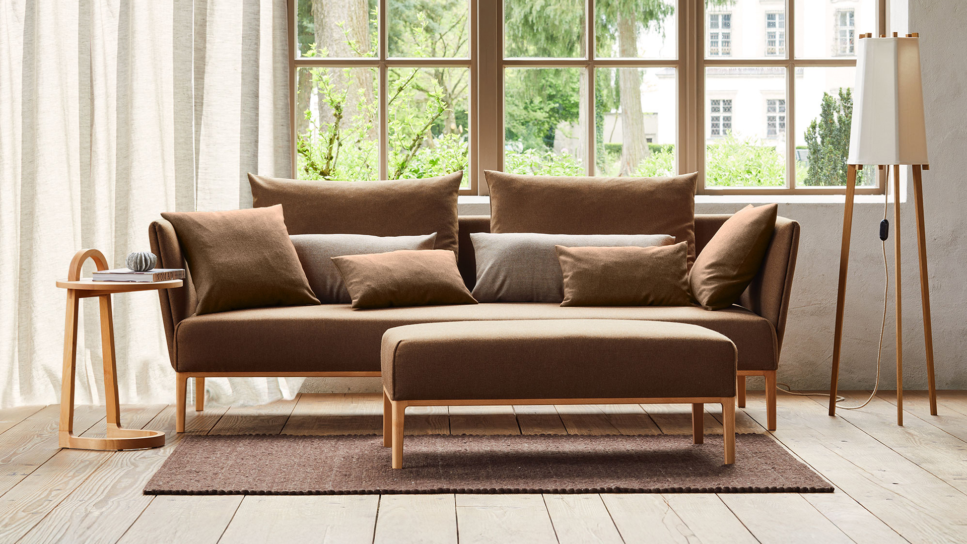 Einzelsofa Lorea mit Hocker und Beistelltisch im Wohnzimmer