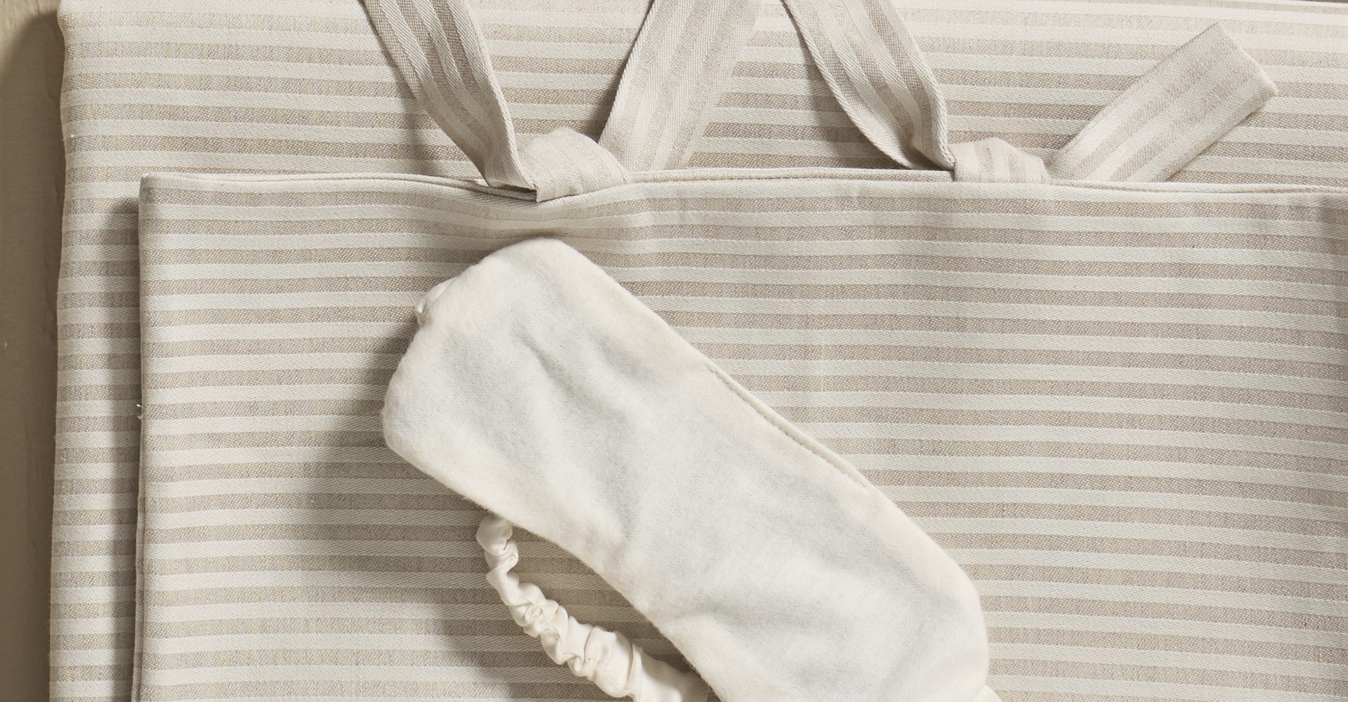 Schlafmaske liegt auf Bettwäsche Henry