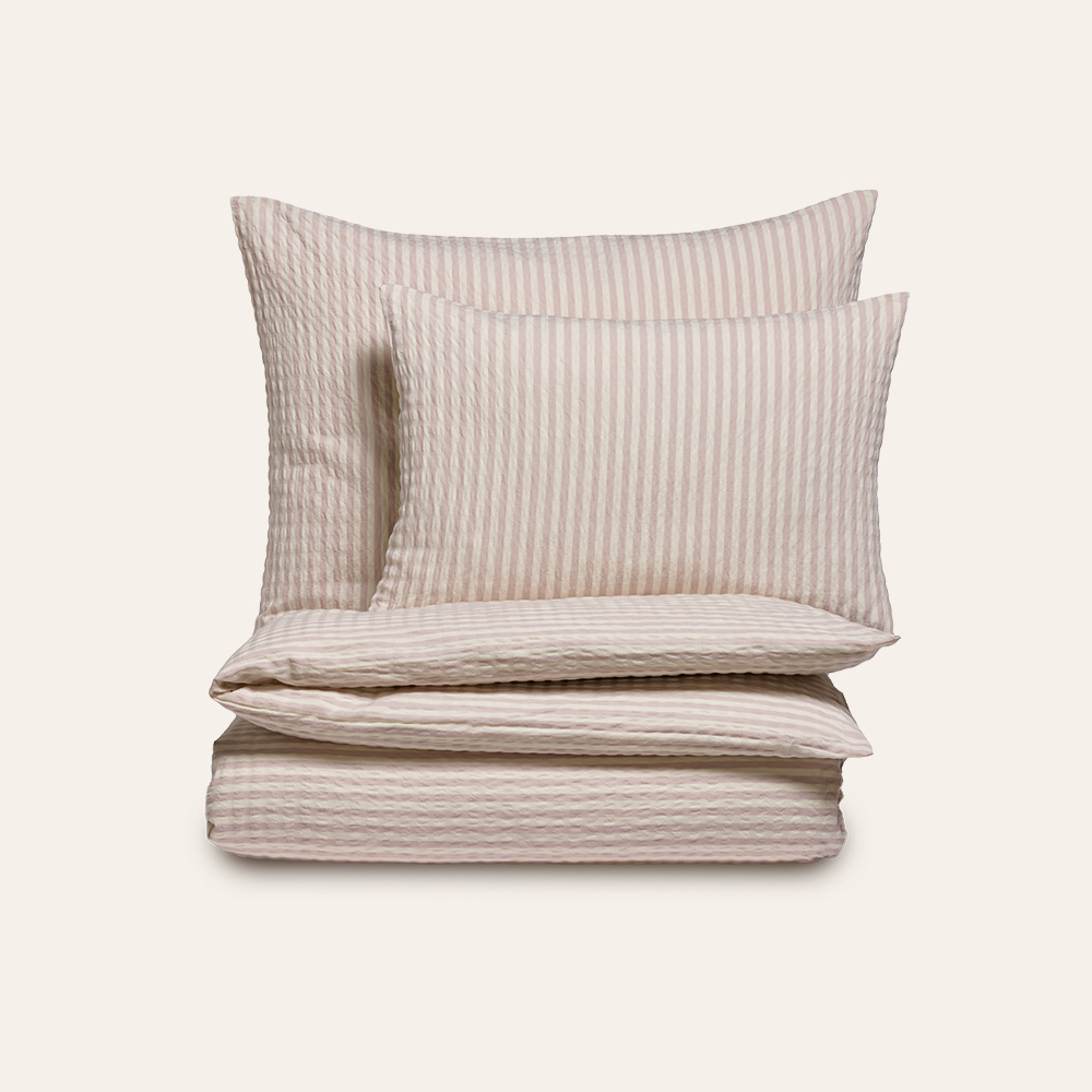Beige Bettwäsche mit Streifenmuster auf weißem Hintergrund