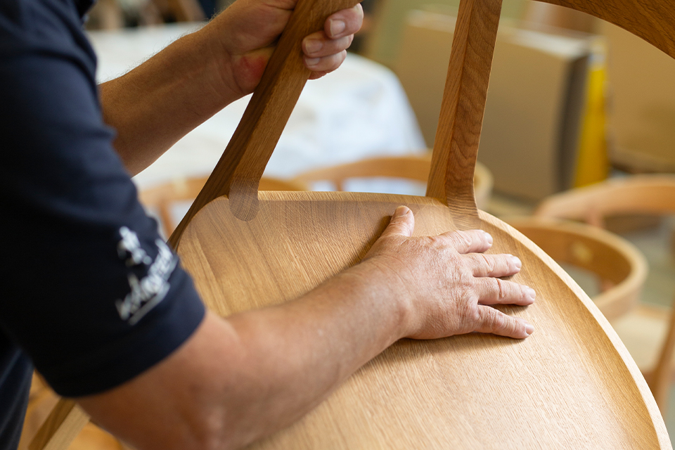 handwerkliche Bearbeitung eines hochwertigen Holzstuhls