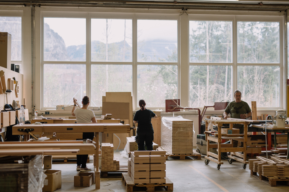 Mitarbeiter vor einer großen Glaswand die den Produkten den letzten Schliff verleihen