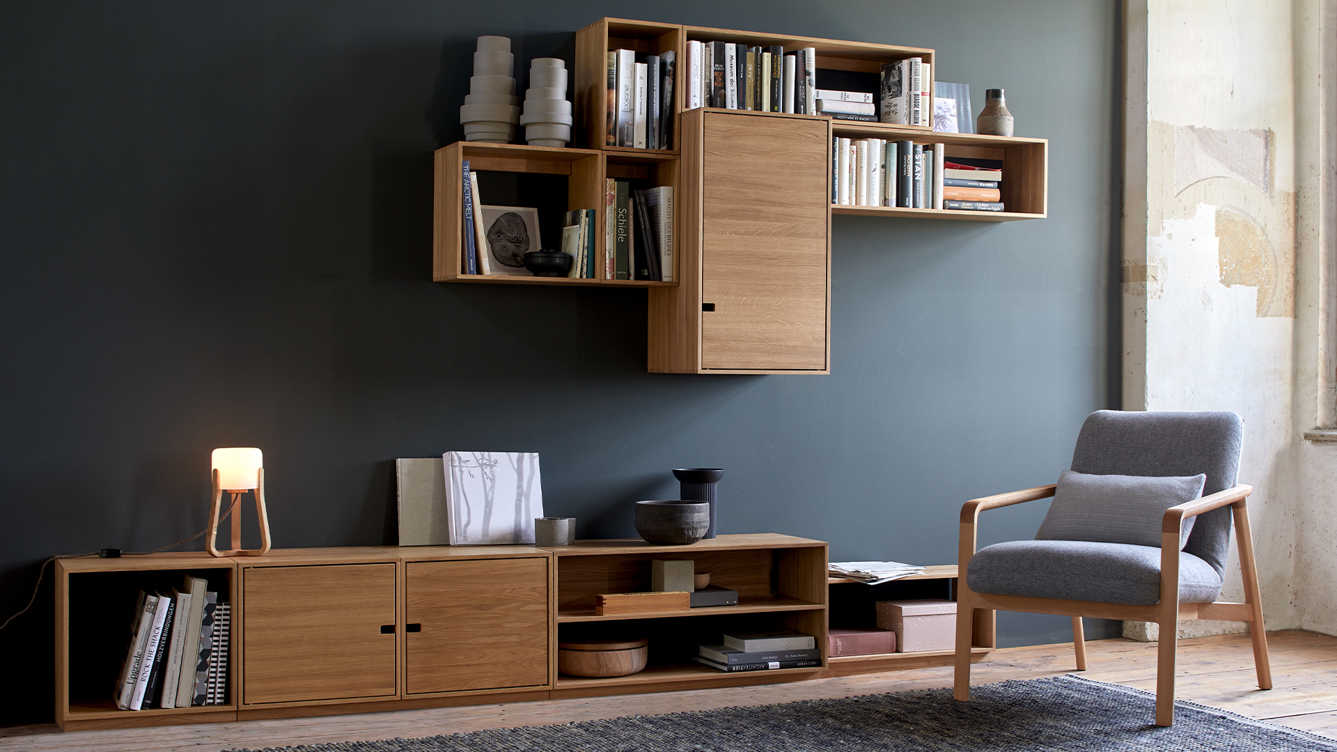 Esempio Wohnwand Beispiel an einer grauen Wand im Raum