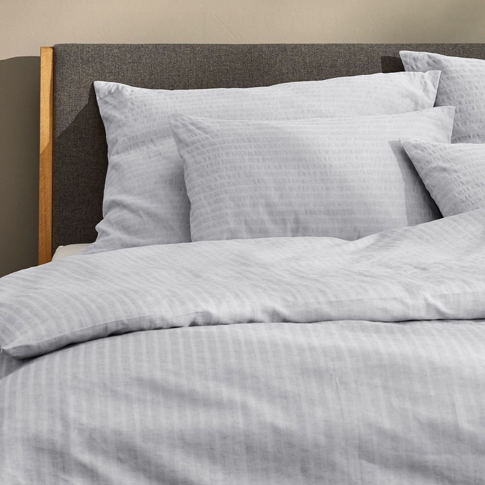 Hellblaue Bettwäsche im dunkelgrauen Bett