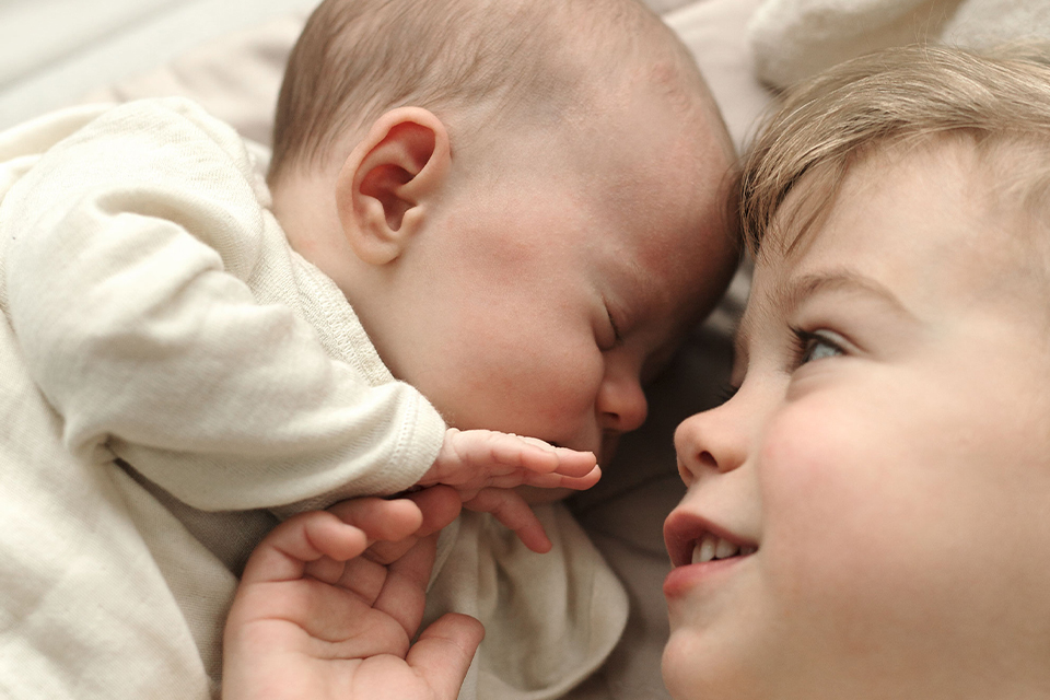 Ein Baby schläft Kopf an Kopf mit seinem Geschwisterchen