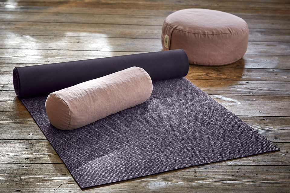 Yogamatte und Kissen auf Holzboden für entspannte Übungen