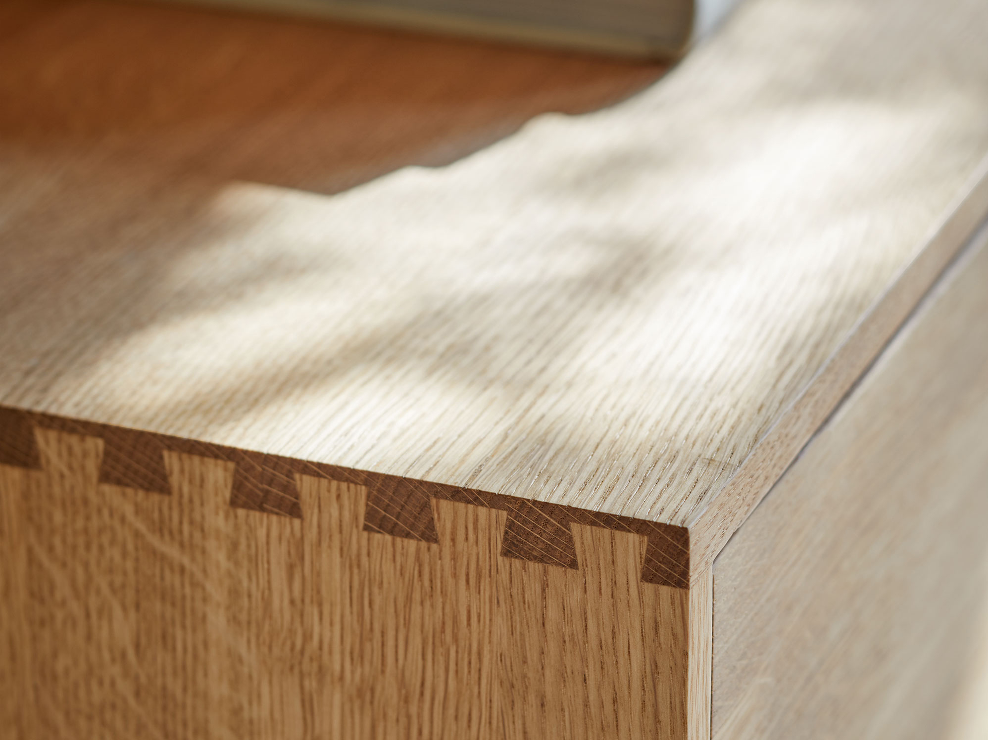 Detailaufnahme einer Holzverbindung aus Fingerzinken an einem Wohnschrank