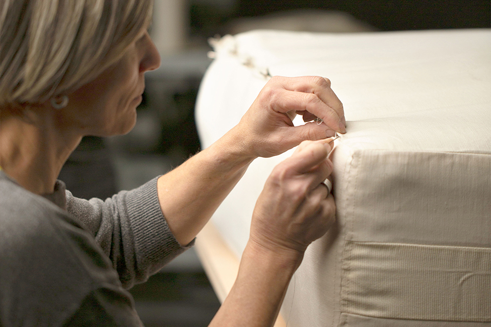 Eine Mitarbeiterin beim Zusammennähen einer hochwertigen Naturmatratze