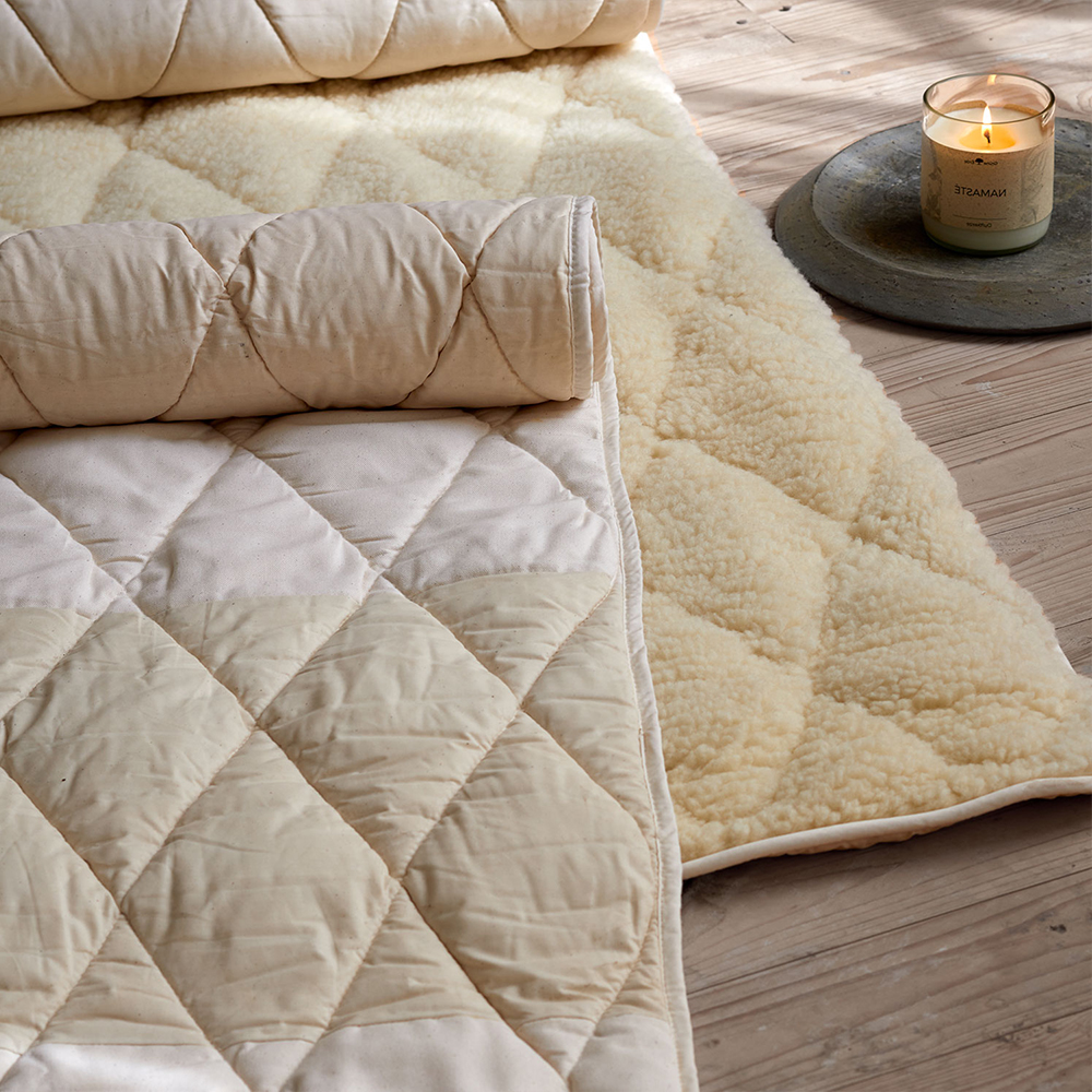 Yogamatten auf Holzboden mit brennender Duftkerze in ruhiger Umgebung