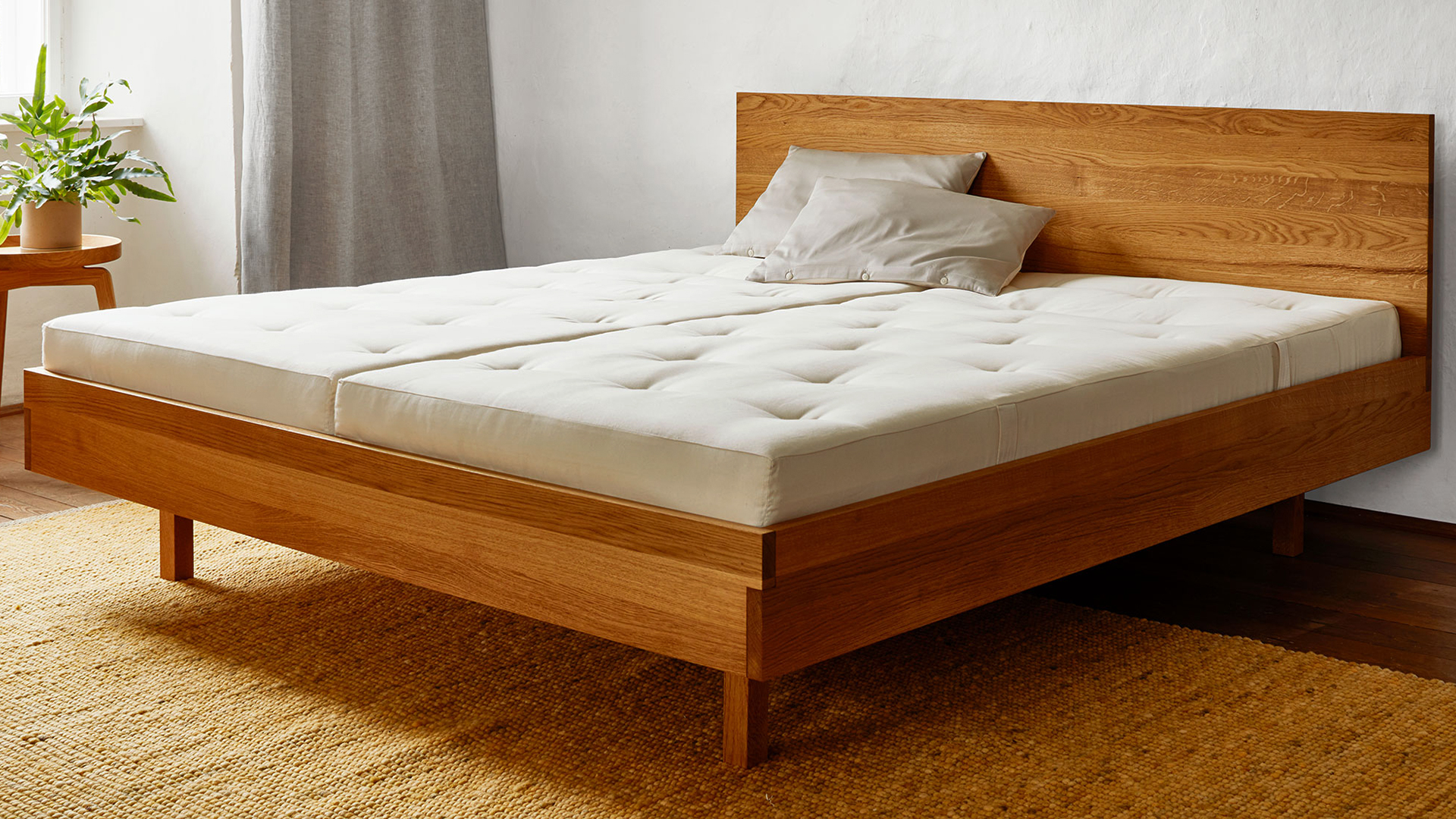 Bett Tesoro mit hochwertigen Naturmatratzen vor einem großen Fenster