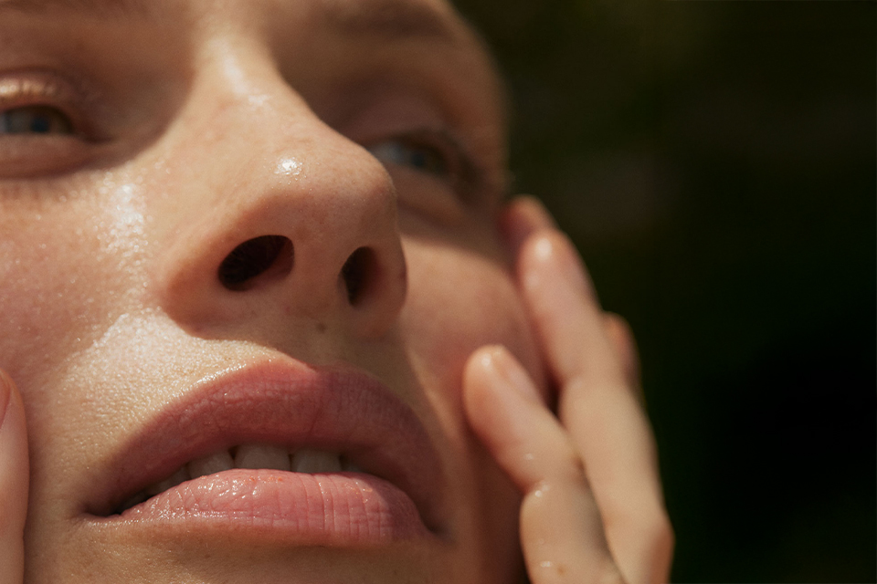 Nahaufnahme einer Frau mit ihren Händen an den Wangen