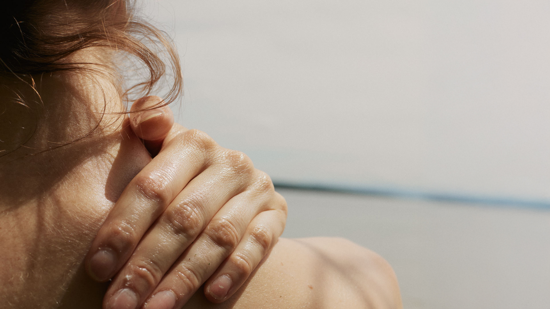 Frau reibt sich ihren Nacken