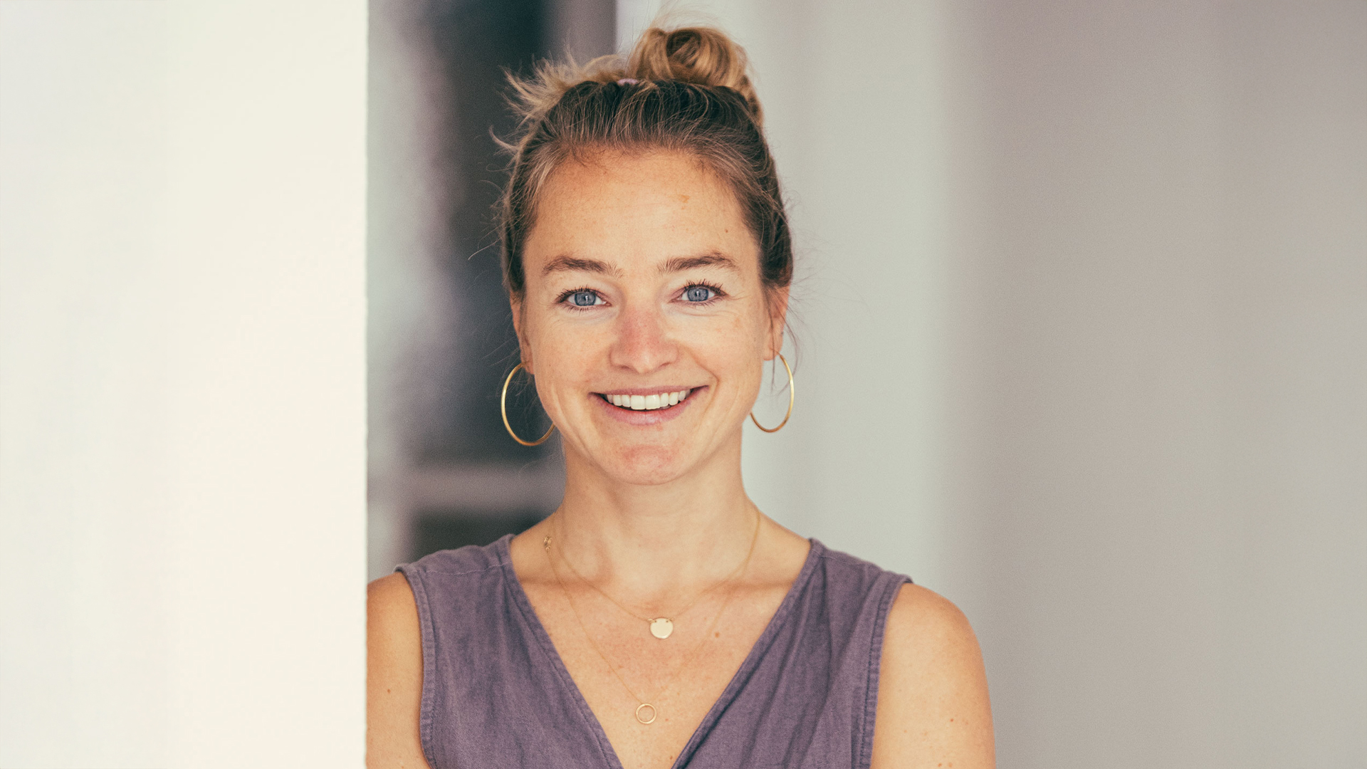 Lächelnde Frau steht im Raum