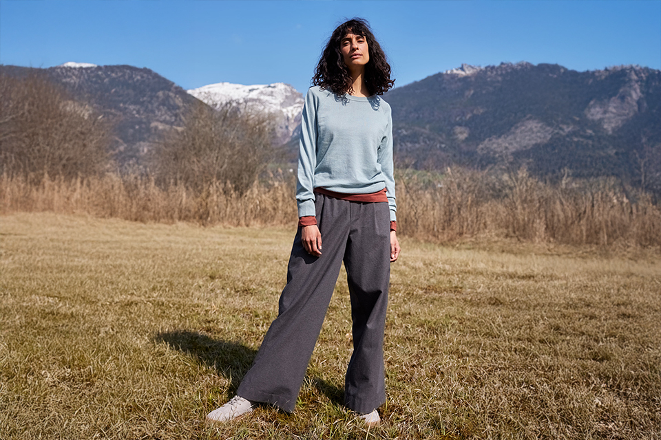 Frau in bequemer Kleidung steht vor Berglandschaft