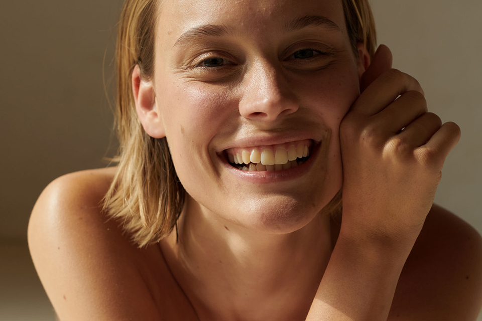 Lachende Frau mit natürlicher Ausstrahlung im weichen warmen Licht