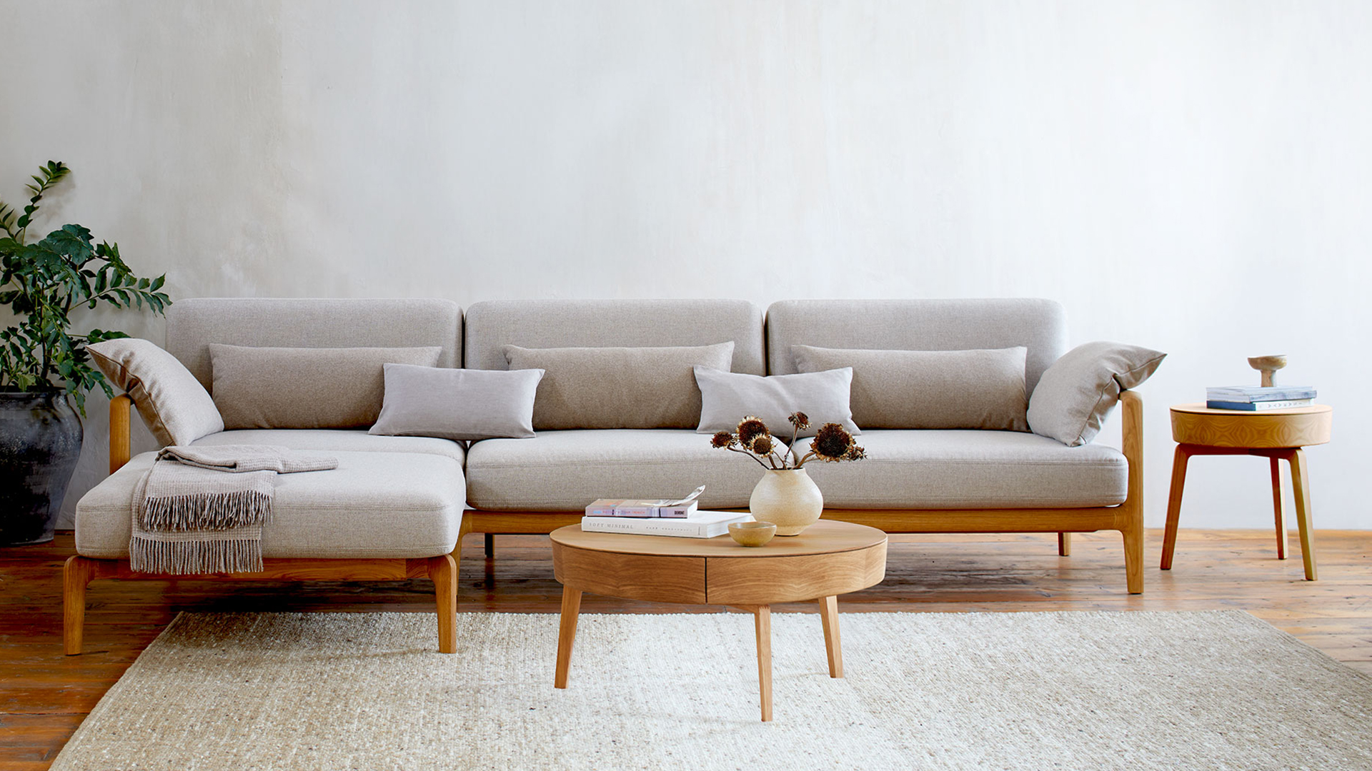 Großzügiges Wohnzimmer mit modernem Sofa und hellen natürlichen Materialien