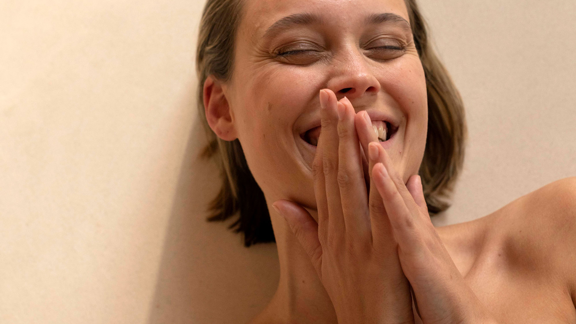 Lachende Frau mit zusammengefalteten Händen