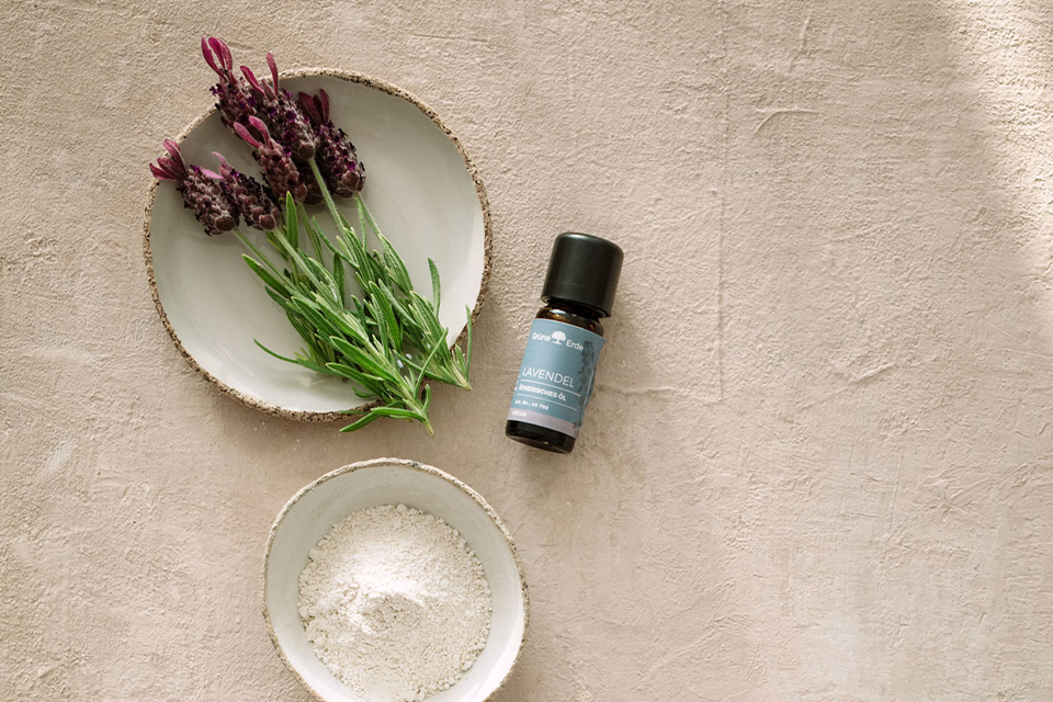 Aromaöl und Zucker in einer Schale  neben dekorativen Blumen