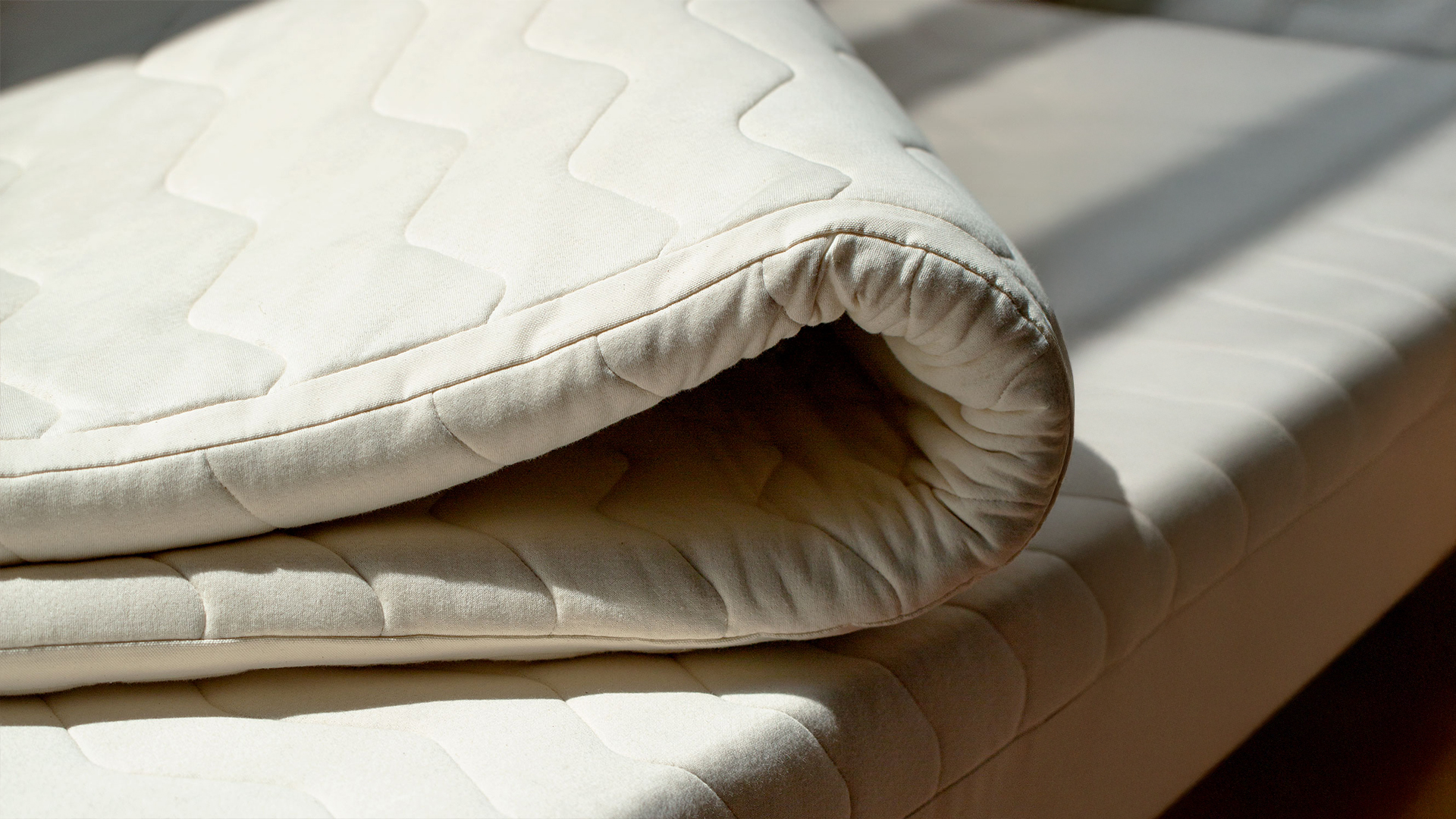zusammengeklappter Topper liegt auf Matratze