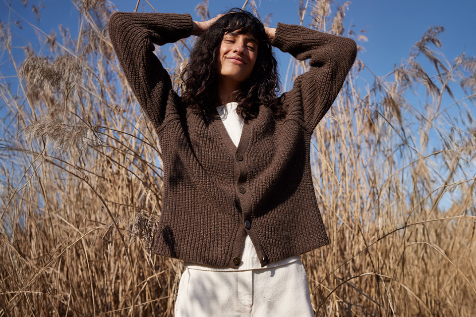Frau im braunen Pullover genießt Sonne im Freien