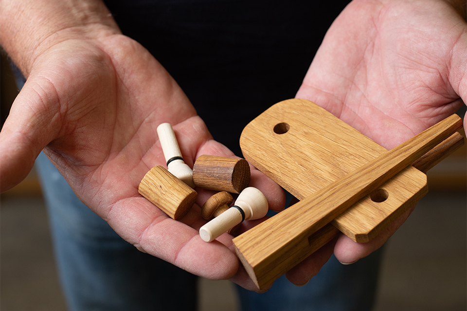 zwei geöffnete Hände die Holzverbindungen halten