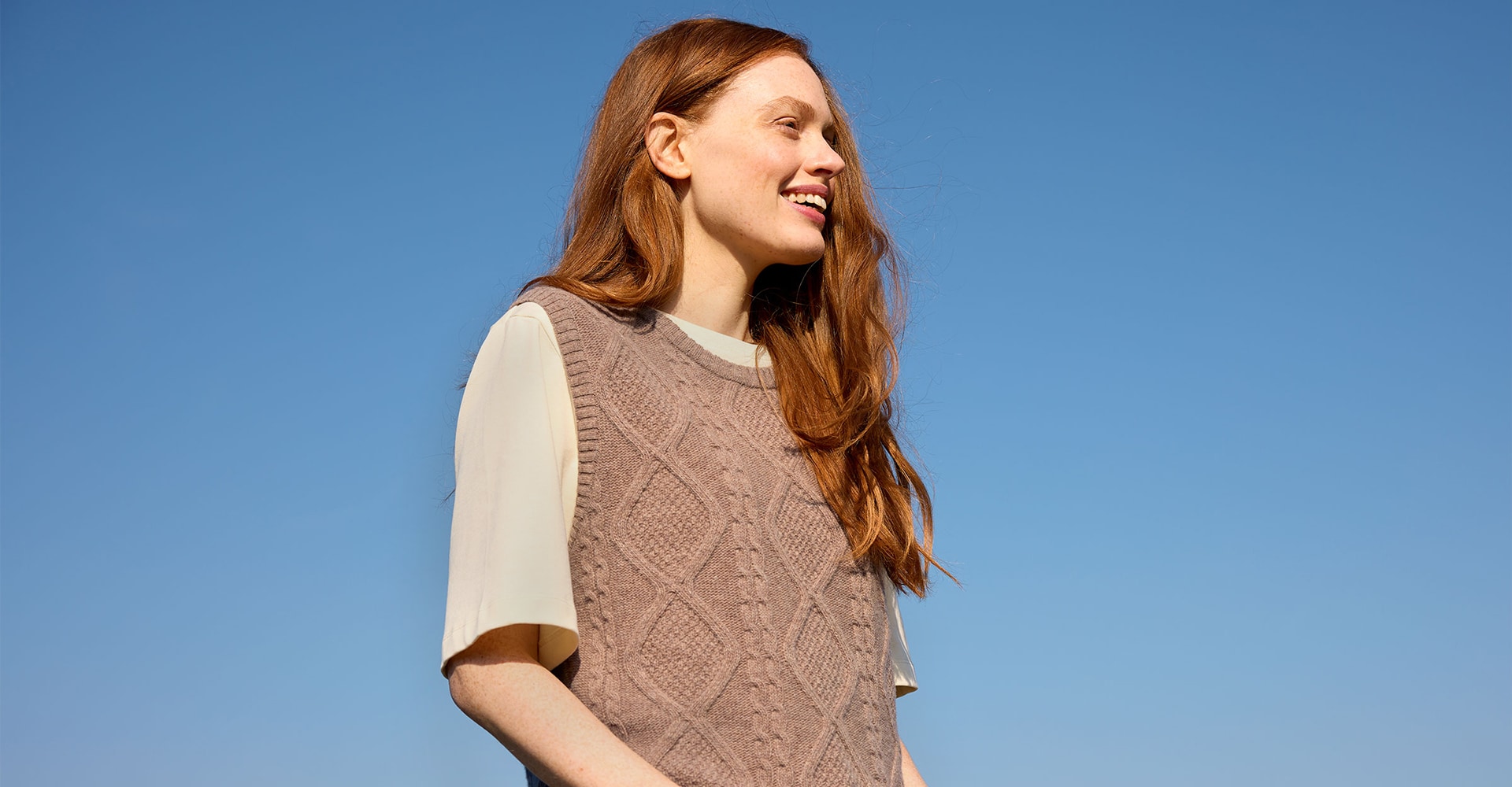 Lächelnde Frau trägt gestrickten Pullover