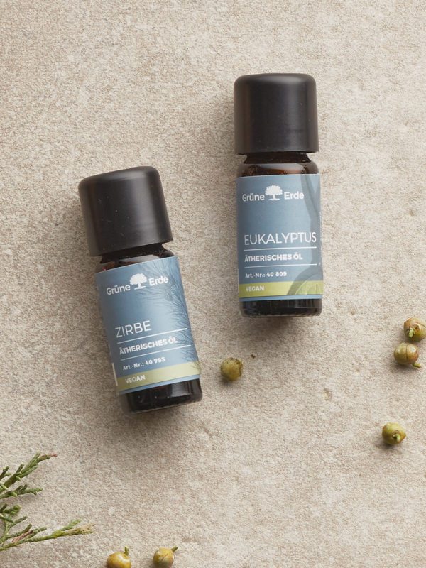 Ätherische Öle und eine Schale mit Öl nebeneinander angeordnet