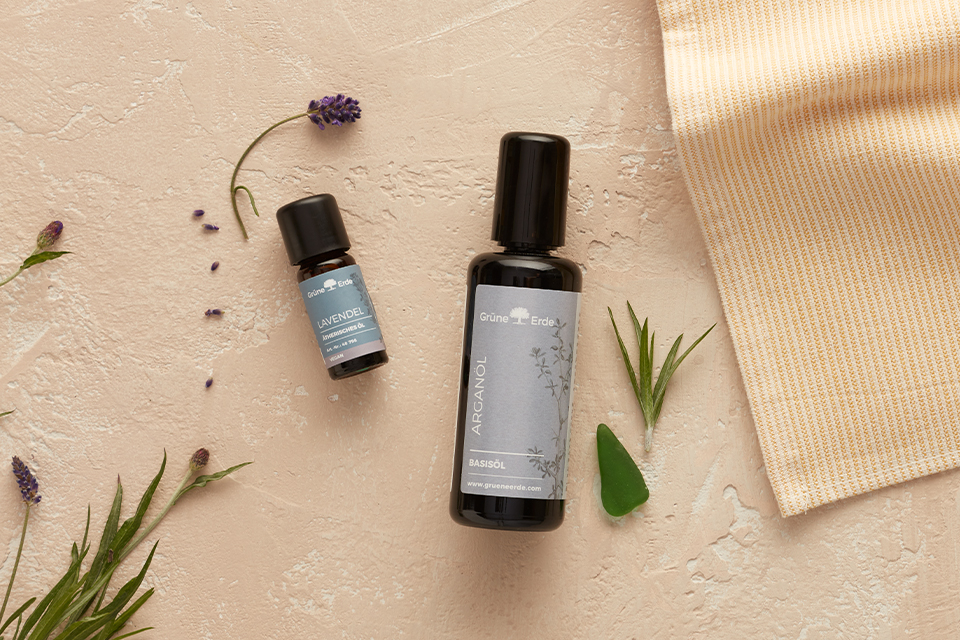 Basisöl und Aromaöl mit dekorativen Pflanzen auf hellem Untergrund