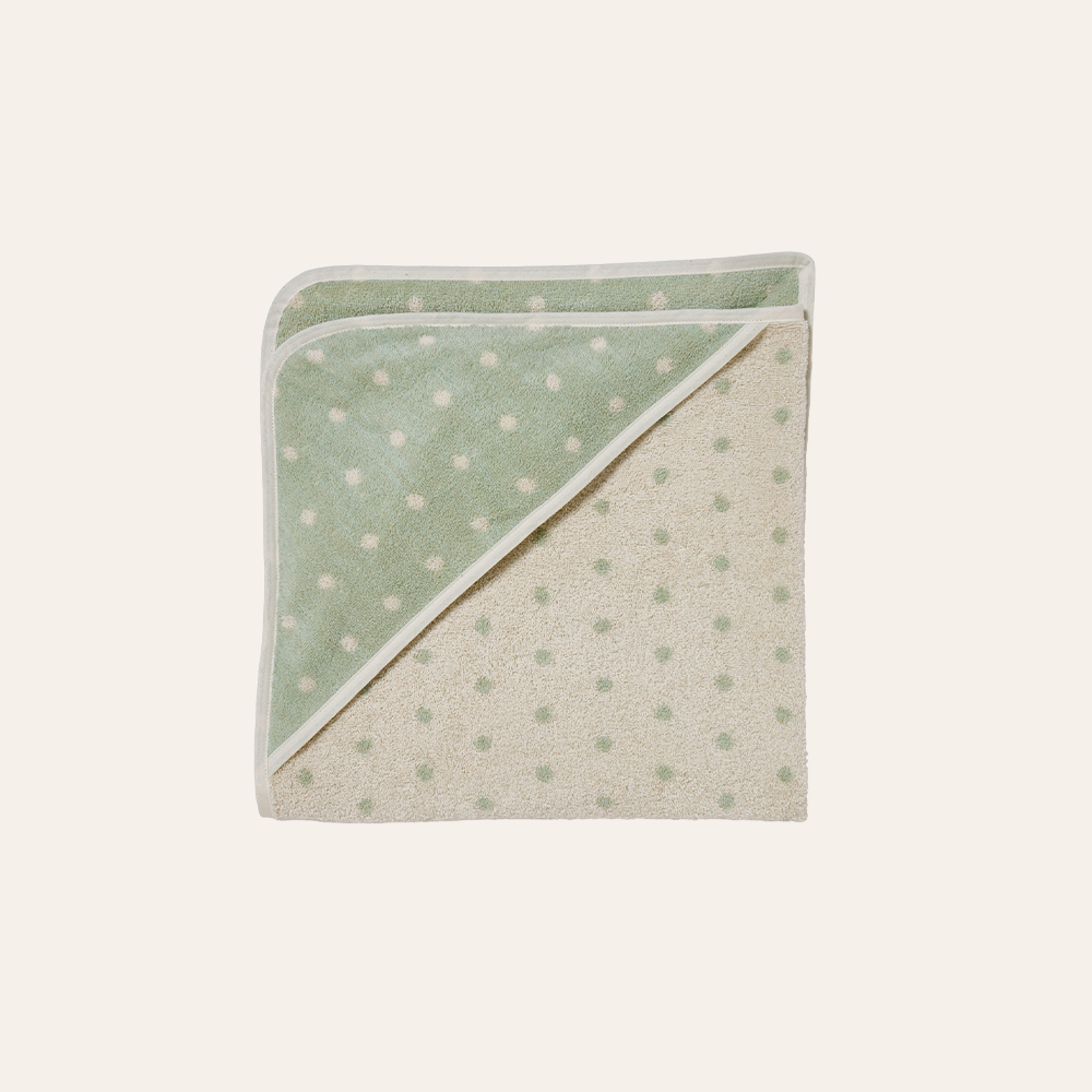 Handtuch mit Pünktchenmuster vor weißem Hintergrund