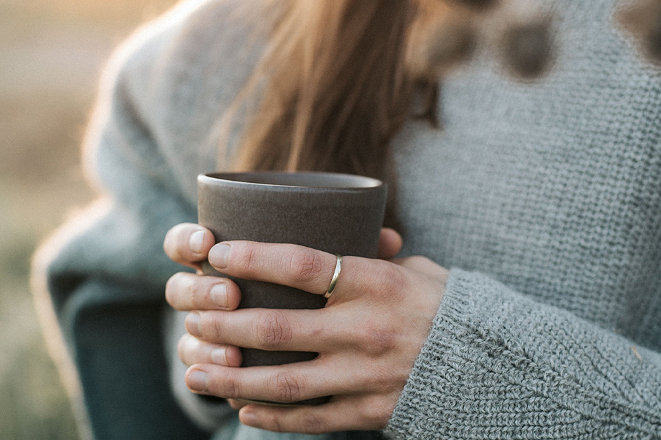 Eine Tasse wird mit zwei Händen gehalten