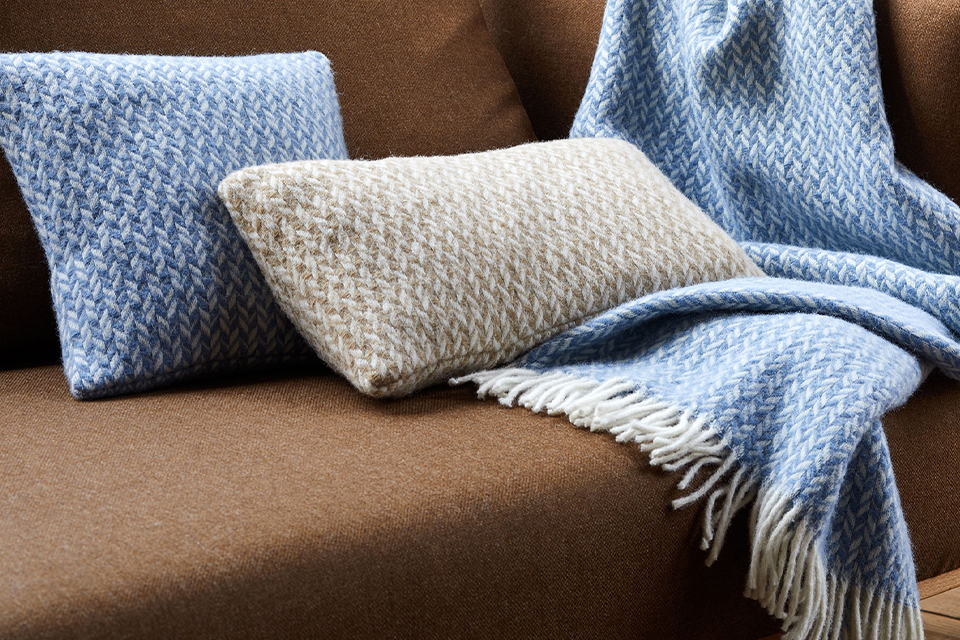 Ausschnitt von Couch mit Sofakissen und Wohndecke