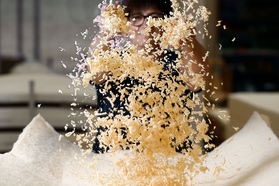 Frau wirft Zirbenspäne in die Luft