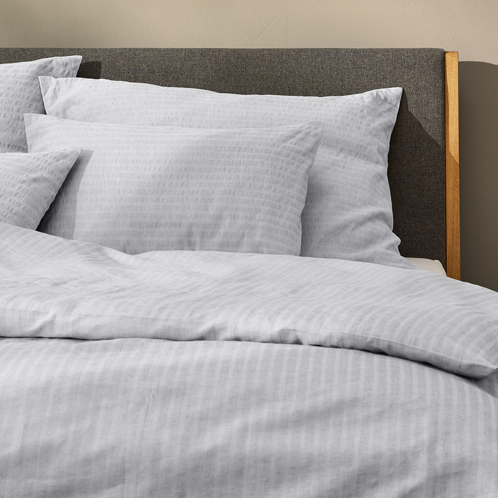Hellblaue Bettwäsche im dunkelgrauen Bett