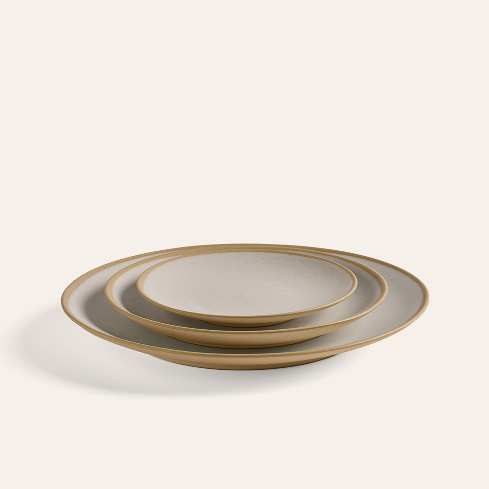 Drei Teller der Größe nach aufgestapelt vor weißem Hintergrund