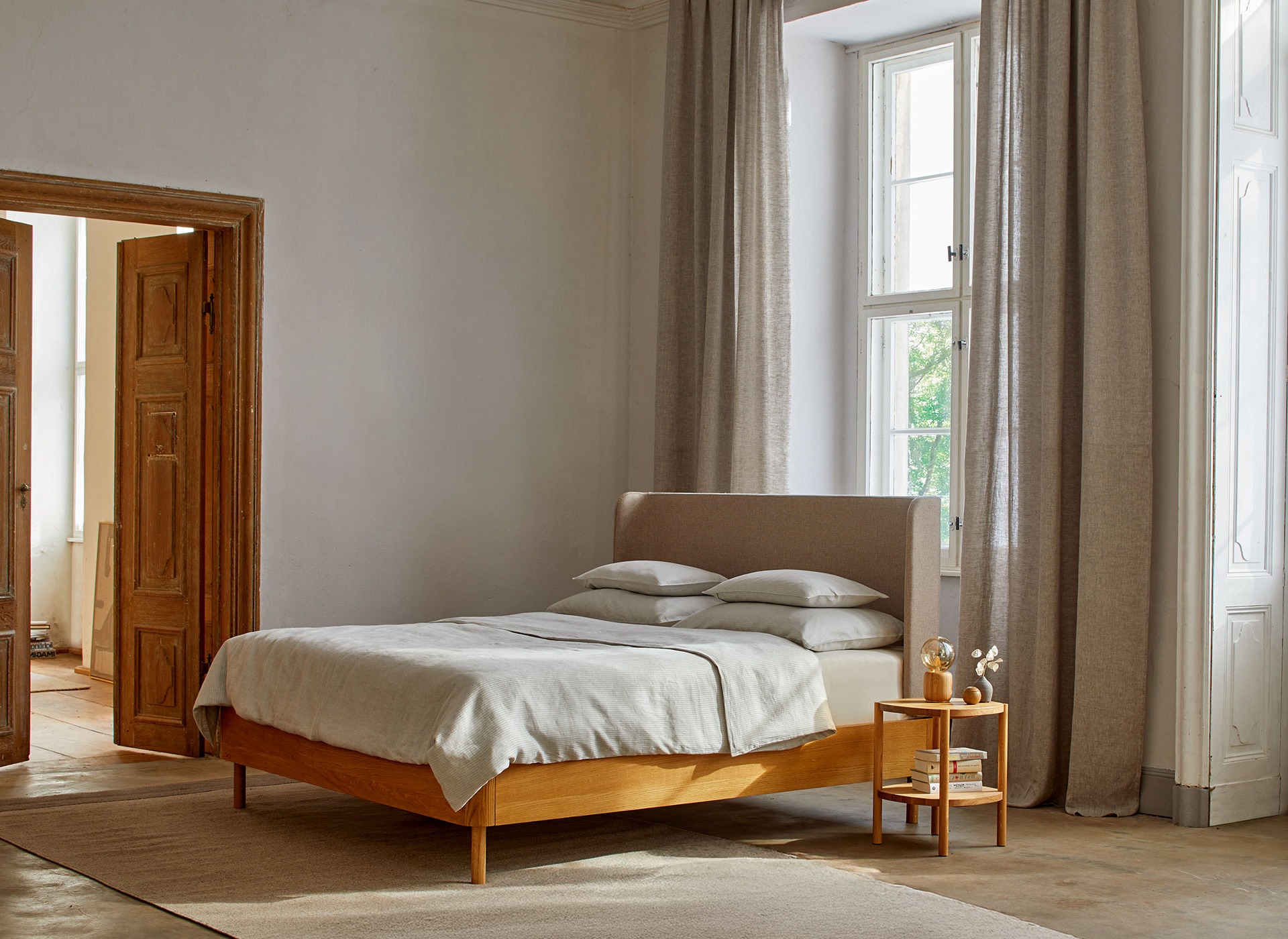 Massivholz Doppelbett Tonda mit hohem Betthaupt und Nachtkästchen im Schlafzimmer