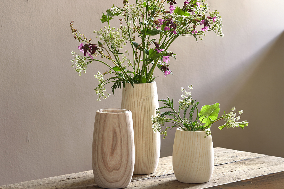 Zwei Vasen mit Blumen stehen dekorativ auf Tisch im Licht