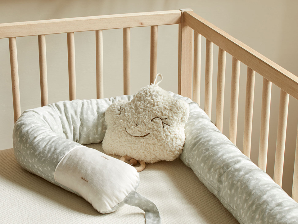 Schlafschlange und Spieluhr Wölchen im Kinderbett liegend