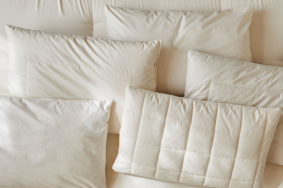 5 verschiedene hochwertige Kopfkissen auf einer ökologischen Naturmatratze