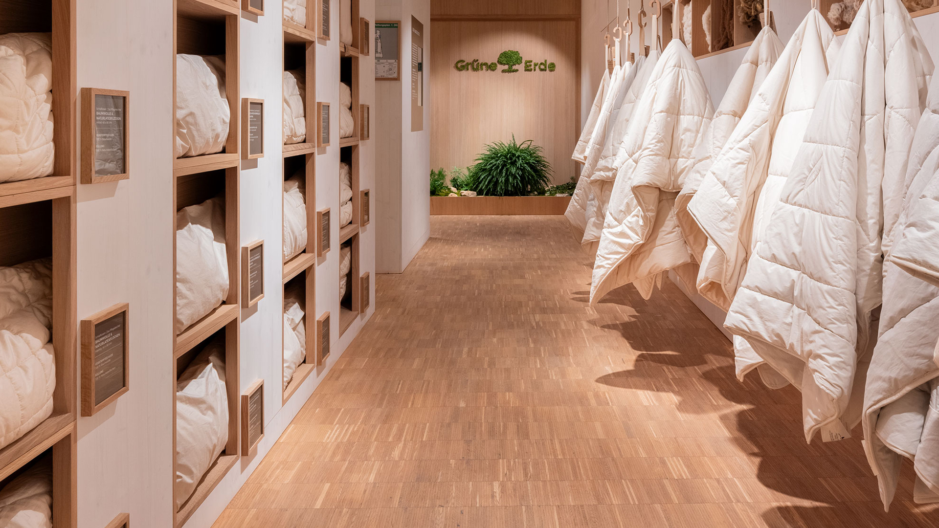 Innenansicht eines Stores mit Regalen und hängenden Bettdecken