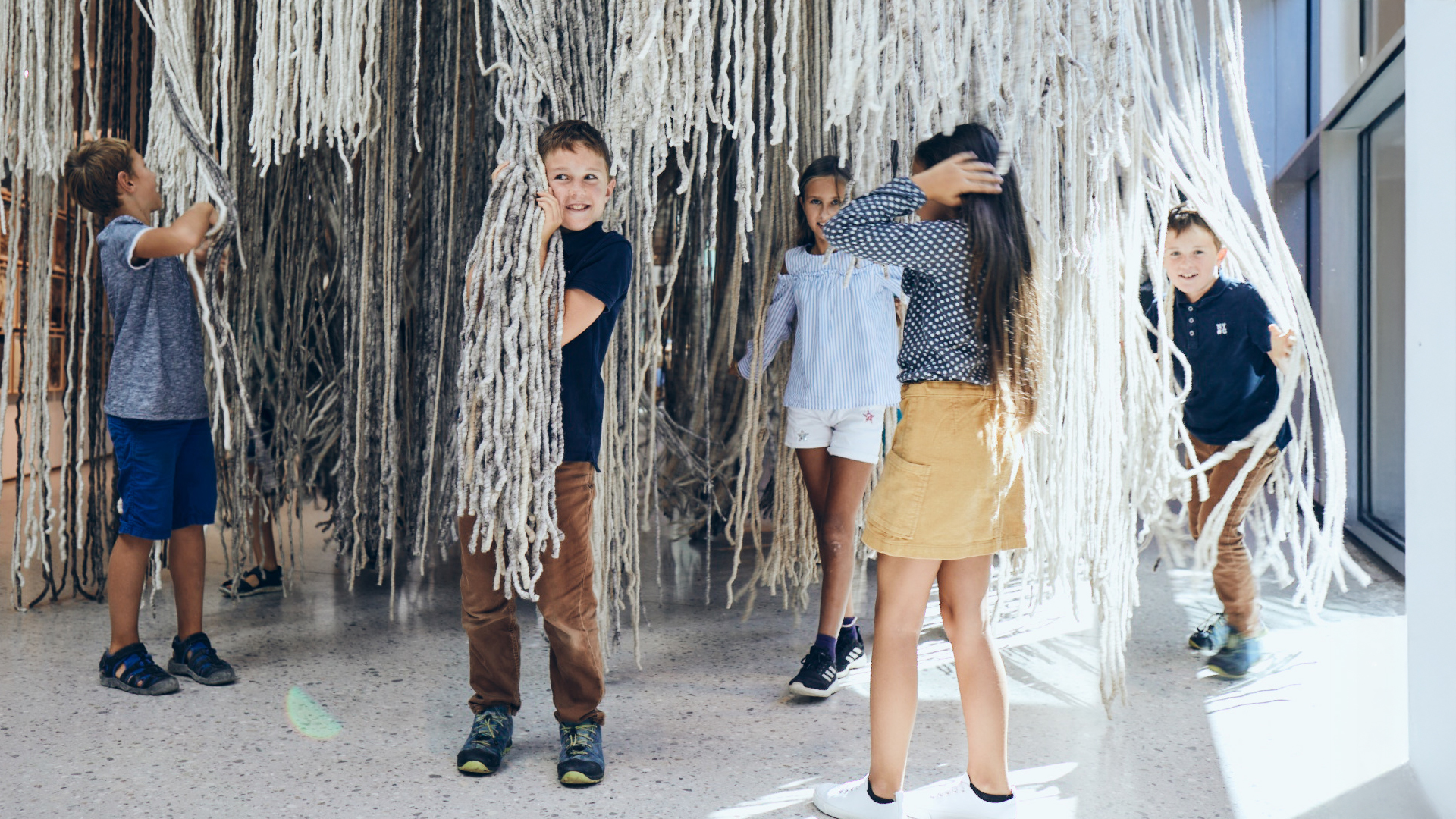 Kinder stehen im Raum und erkunden interaktive Ausstellung gemeinsam