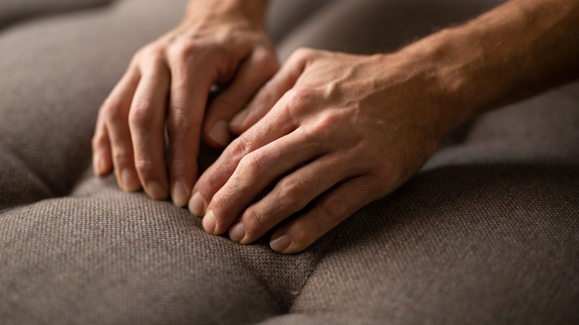 Hände drücken auf gepolsterte Oberfläche