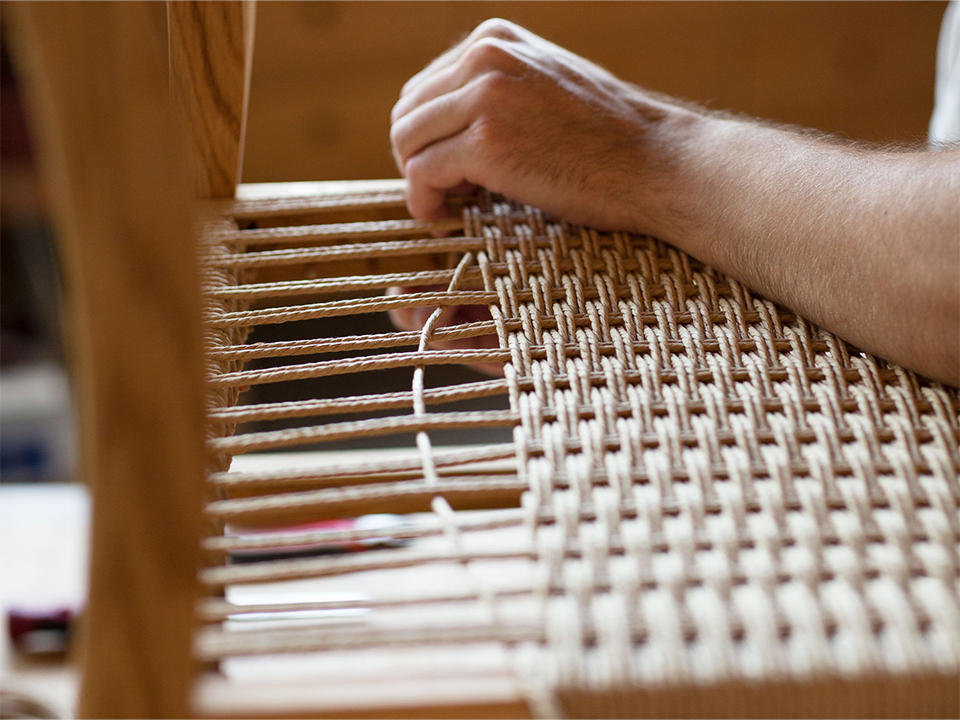 Stuhlsitzfläche wird aus einer Papierschnurr geflochten