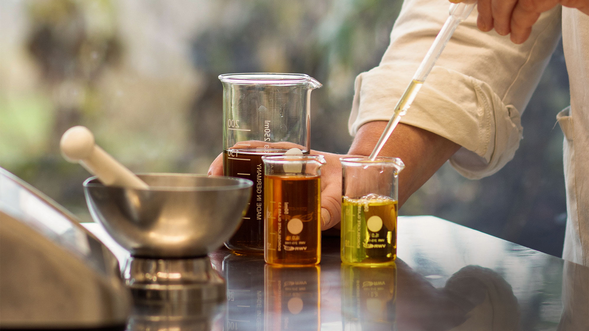 Drei Behälter aus Glas mit unterschiedlichen Flüssigkeiten gefüllt