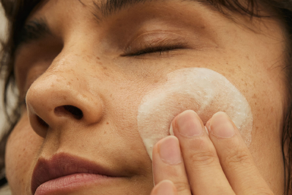 Nahaufnahme eines Frauengesichts mit Creme auf der Wange