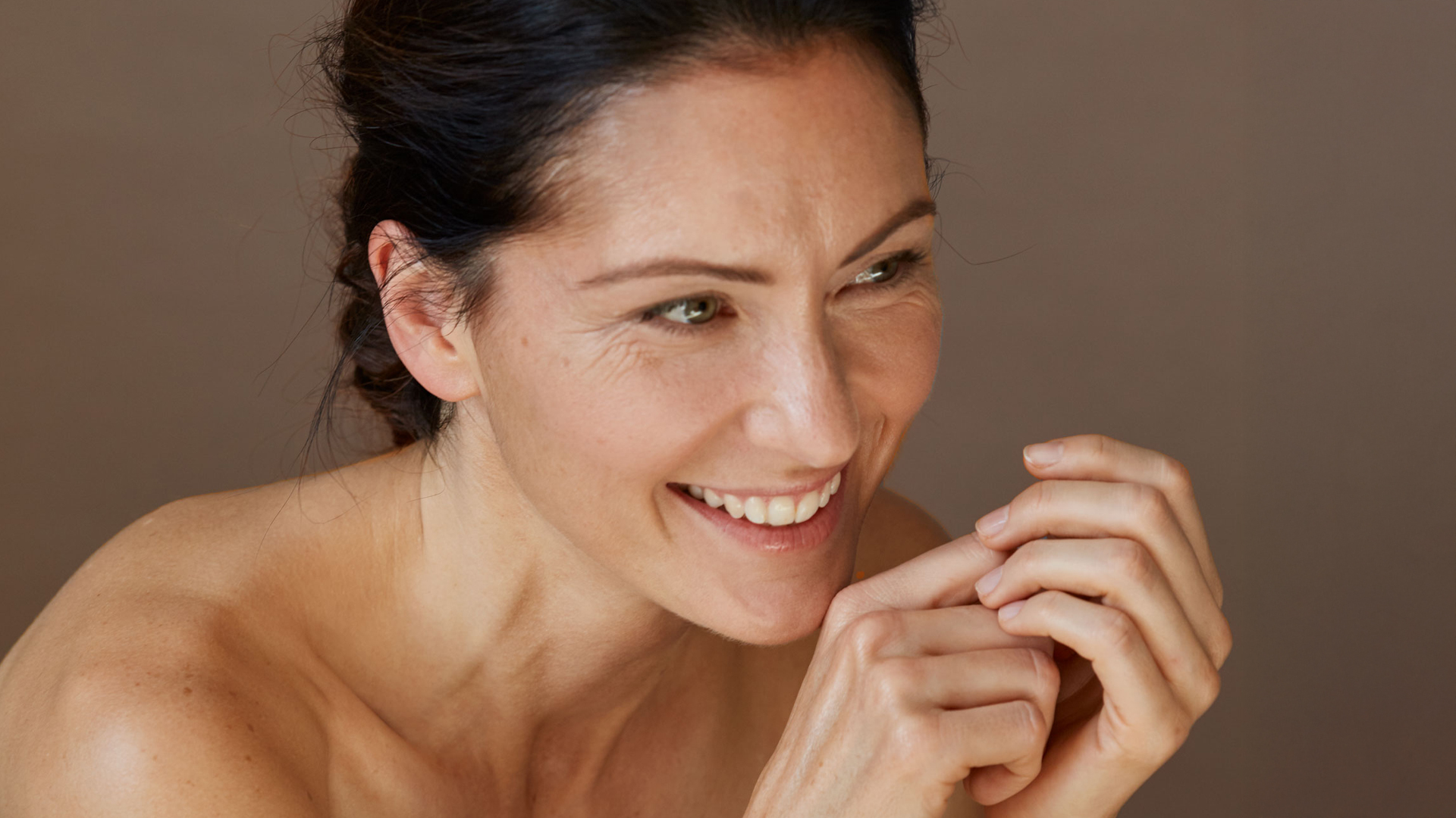 Frau mit dunklen Haaren lächelt
