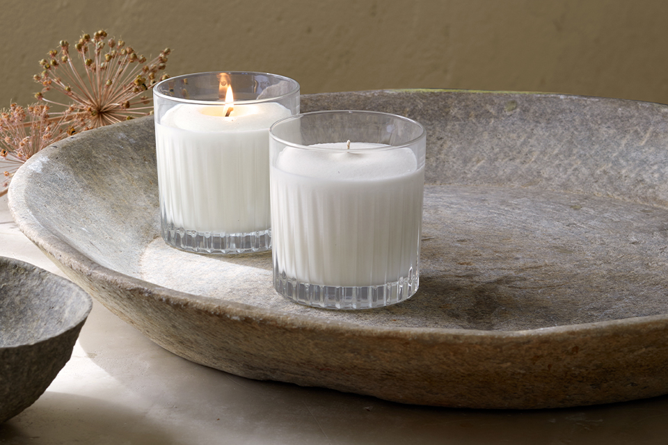 Zwei Weiße Kerzen auf einem Steingut-Teller