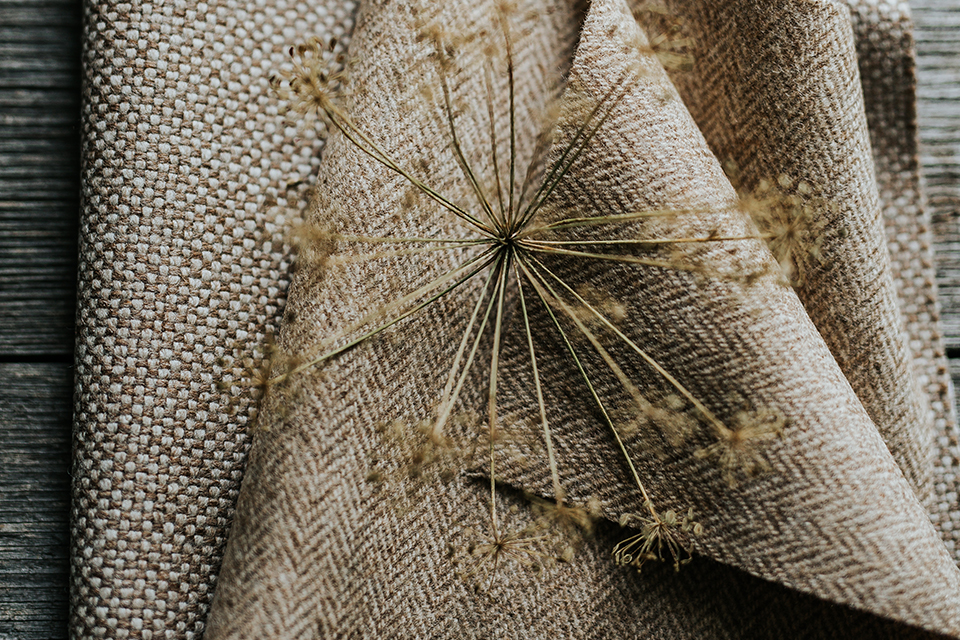 Gefaltete Möbelstoffe mit einer dekorativen Trockenblume