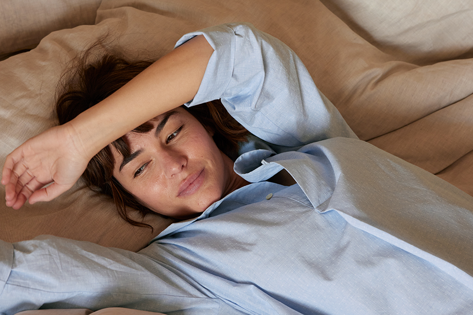 Person liegt entspannt im Bett und genießt ruhigen Moment